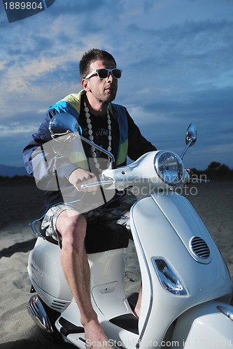 Image of young man ride retro scooter