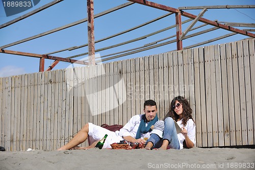 Image of young couple enjoying  picnic on the beach