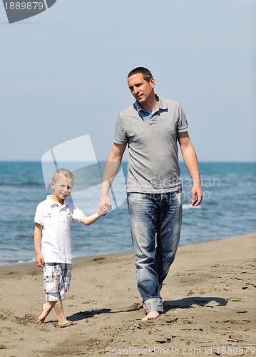 Image of happy father and son have fun and enjoy time on beach