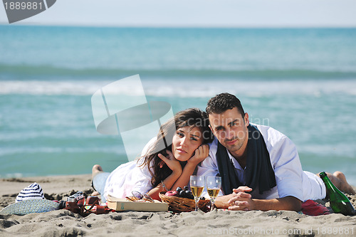 Image of young couple enjoying  picnic on the beach