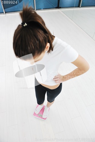 Image of happy diet concept with young woman on pink scale