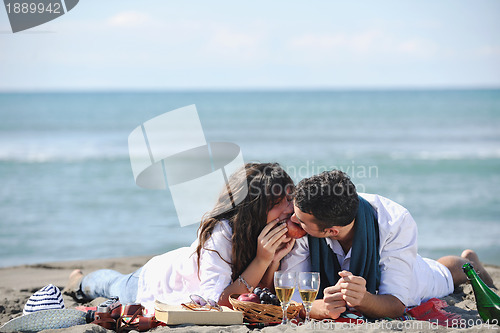 Image of young couple enjoying  picnic on the beach