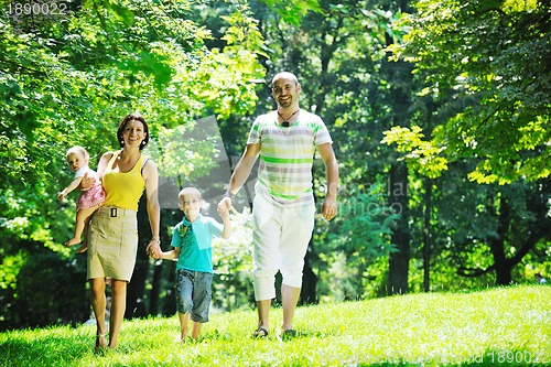Image of happy young couple with their children have fun at park