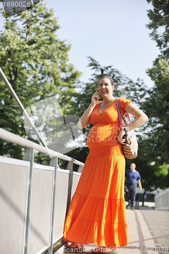 Image of happy pregnant woman talking by cellphone