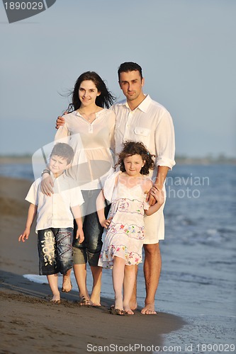 Image of happy young family have fun on beach at sunset