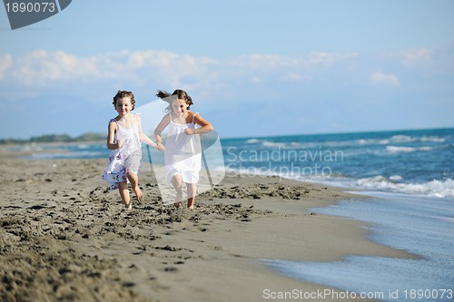 Image of cute little girls running on beach