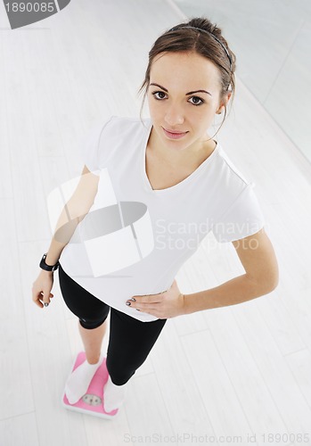 Image of happy diet concept with young woman on pink scale