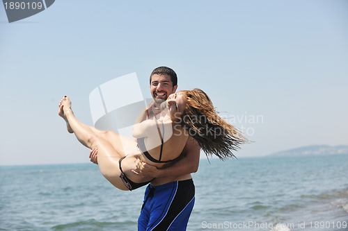 Image of happy young couple have fun on beach