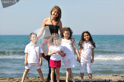 Image of group portrait of childrens with teacher on beach