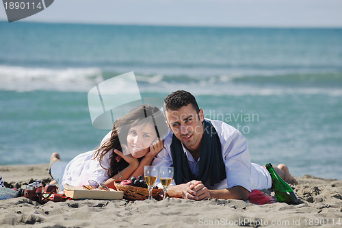 Image of young couple enjoying  picnic on the beach