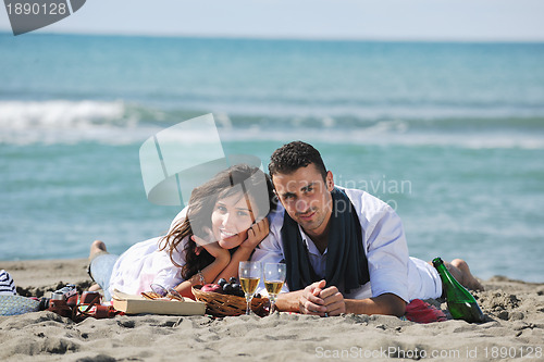 Image of young couple enjoying  picnic on the beach
