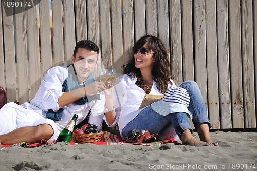 Image of young couple enjoying  picnic on the beach