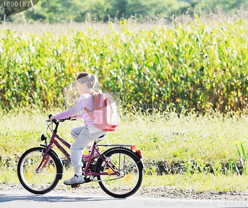 Image of schoolgirl traveling to school on bicycle