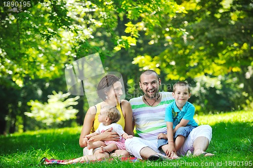 Image of happy young couple with their children have fun at park