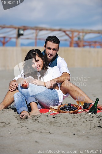 Image of young couple enjoying  picnic on the beach