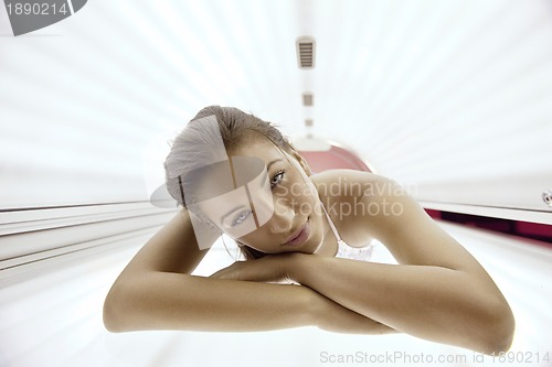 Image of Beautiful young woman tanning in solarium