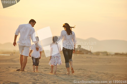 Image of happy young family have fun on beach at sunset