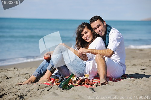 Image of young couple enjoying  picnic on the beach