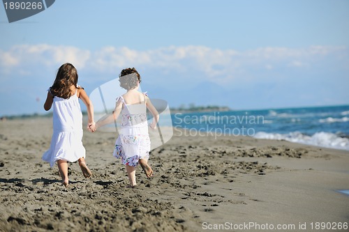 Image of cute little girls running on beach