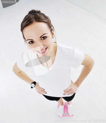 Image of happy diet concept with young woman on pink scale