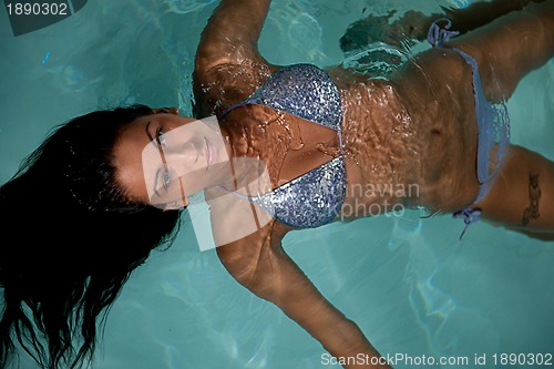 Image of pretty young lady  relaxing in the swimming pool