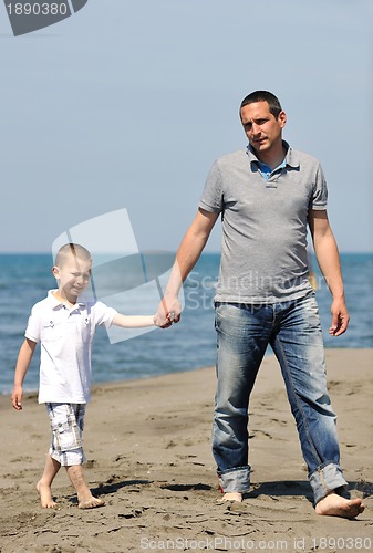 Image of happy father and son have fun and enjoy time on beach