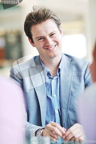 Image of young business man alone in conference room