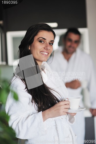 Image of Young love couple taking fresh morning cup of coffee