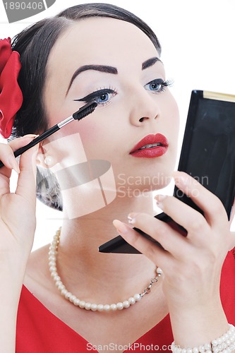 Image of beautiful young woman applying makeup