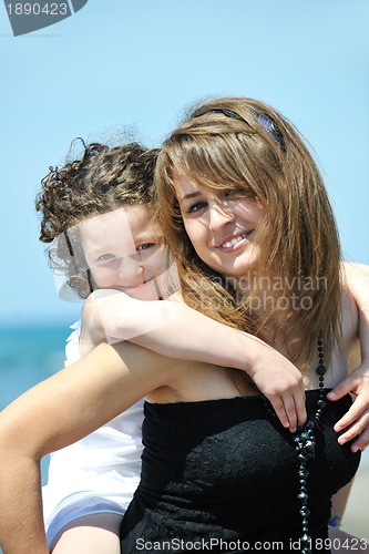 Image of group portrait of childrens with teacher on beach