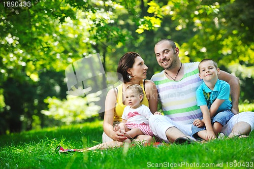 Image of happy young couple with their children have fun at park