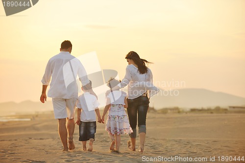 Image of happy young family have fun on beach at sunset