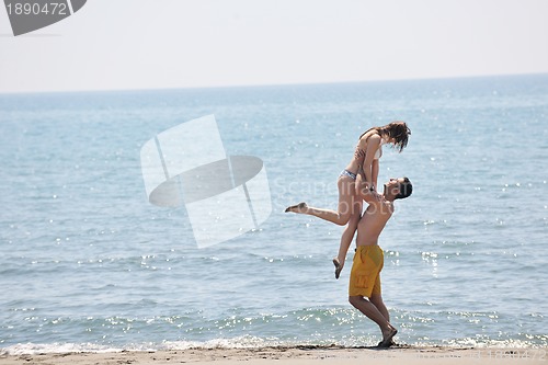 Image of happy young couple have fun on beach