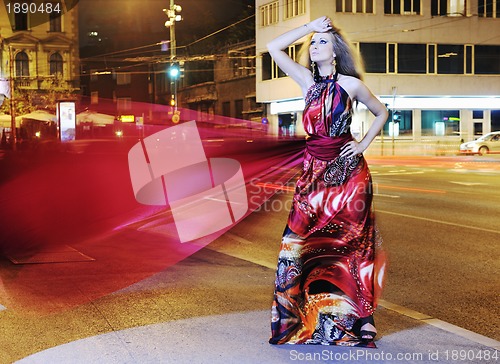 Image of elegant woman on city street at night