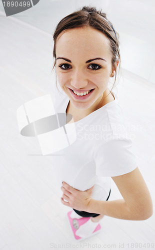 Image of happy diet concept with young woman on pink scale