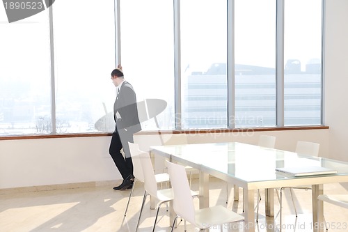 Image of young business man alone in conference room