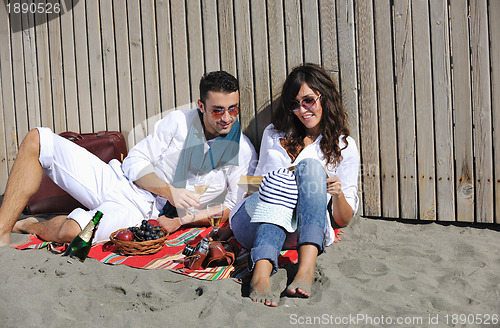 Image of young couple enjoying  picnic on the beach