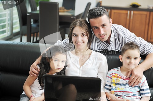 Image of happy young family have fun and working on laptop at home