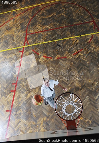 Image of businessman holding basketball ball