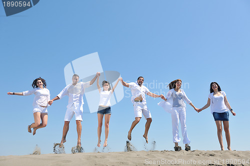 Image of happy people group have fun and running on beach