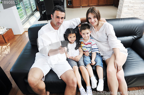 Image of family wathching flat tv at modern home indoor