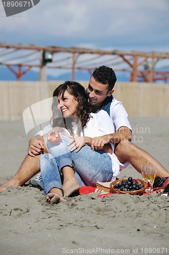 Image of young couple enjoying  picnic on the beach