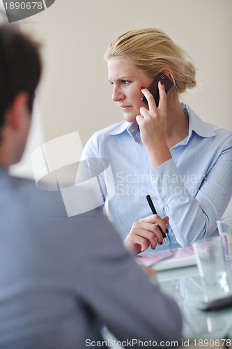 Image of young business woman talk by cellphone on meetng