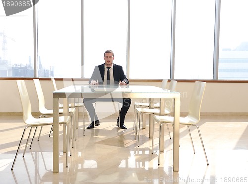 Image of young business man alone in conference room