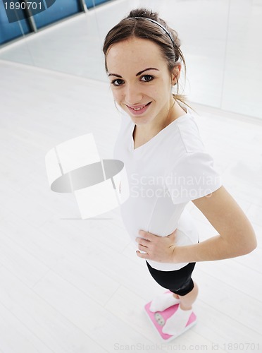 Image of happy diet concept with young woman on pink scale