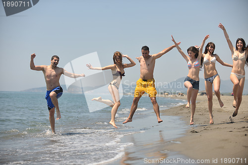 Image of happy people group have fun and running on beach