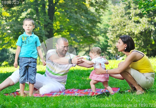 Image of happy young couple with their children have fun at park