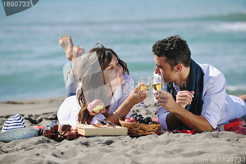Image of young couple enjoying  picnic on the beach