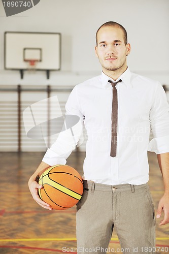 Image of businessman holding basketball ball