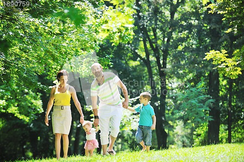 Image of happy young couple with their children have fun at park